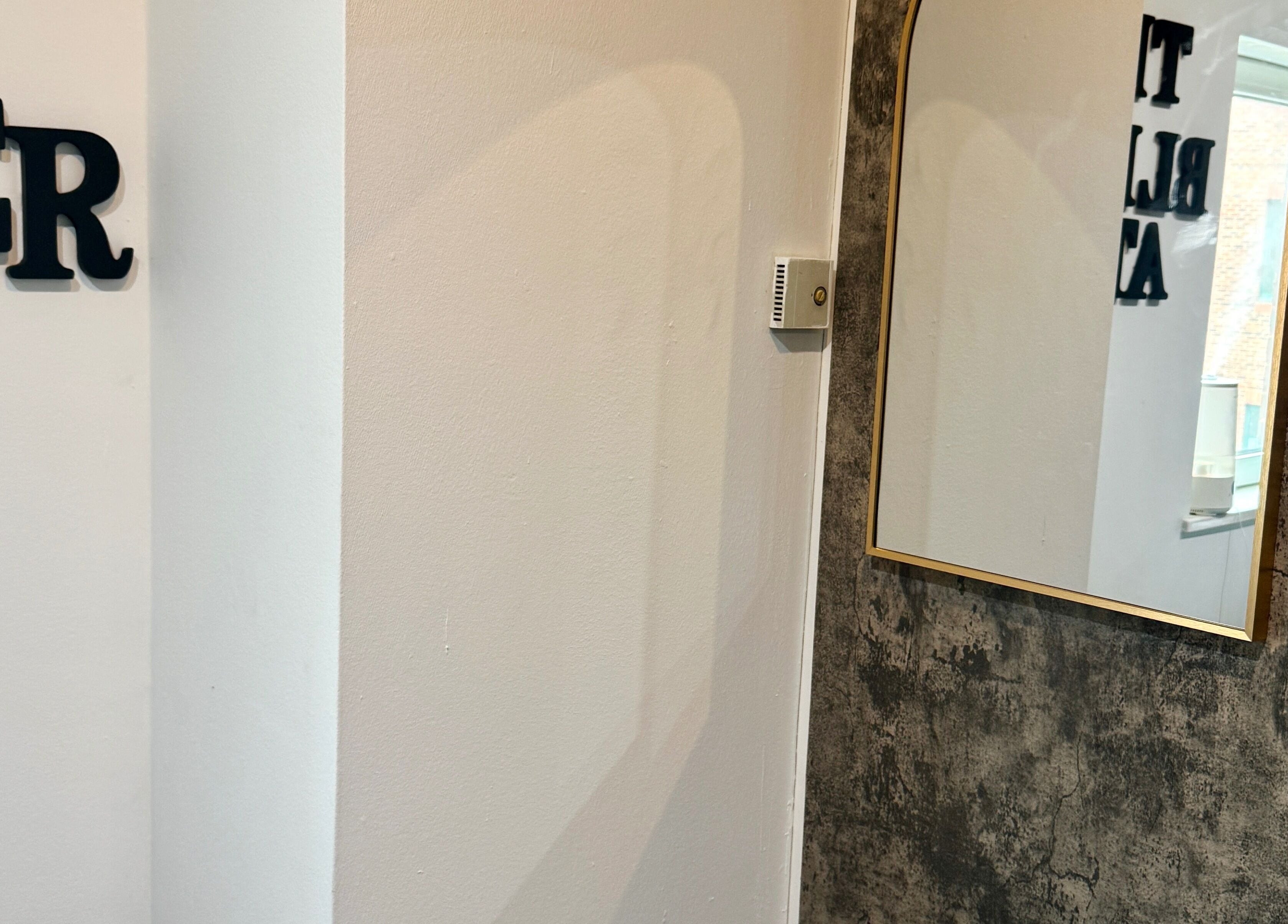 Elegant mirror on a textured wall at The Blink Atelier LDN, London, England, GB.