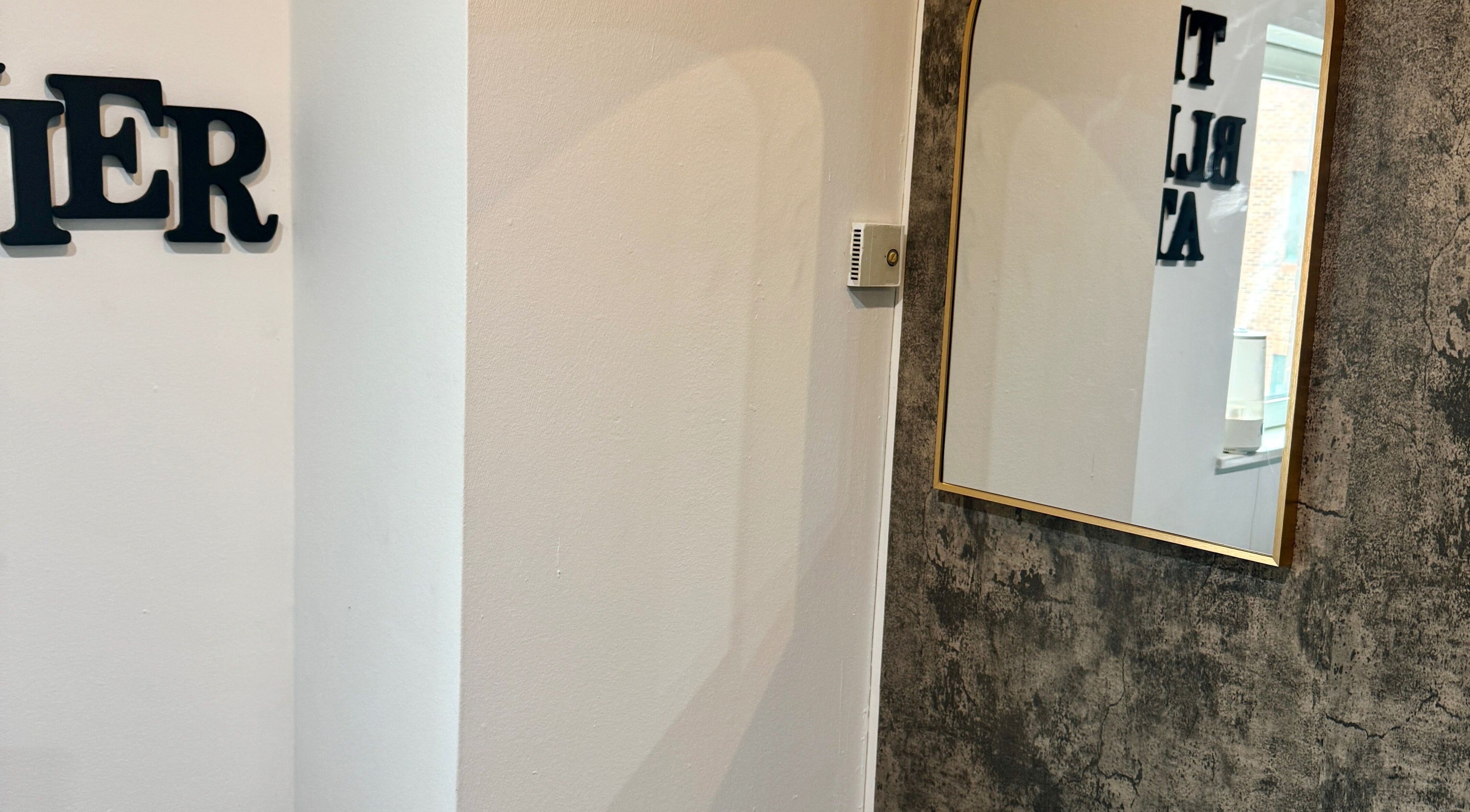 Elegant mirror on a textured wall at The Blink Atelier LDN, London, England, GB.