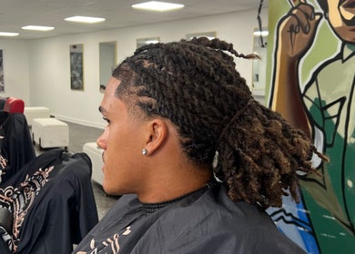 Man with trendy braids at MG TRIMZ, Leeds, England, GB.
