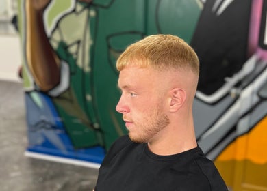 Fresh haircut at MG TRIMZ showcasing style against vibrant mural in Leeds, England, GB.