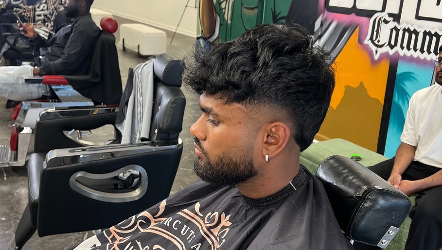 Modern hairstyle at MG TRIMZ barbershop in Leeds, England, GB. A barber attends to a client in a vibrant setting.