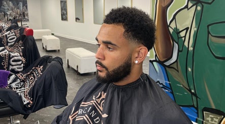 Client with fresh haircut at MG TRIMZ, Leeds, England, GB. Modern salon interior and vibrant art.