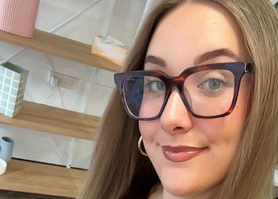 A smiling woman with glasses at The Hair Society By Leearne, Budgewoi, New South Wales, AU.