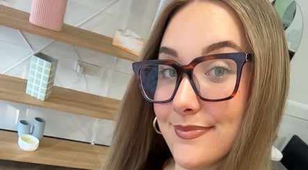A smiling woman with glasses at The Hair Society By Leearne, Budgewoi, New South Wales, AU.