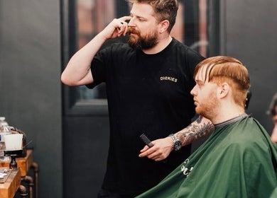 Barber at Lishmans Barbershop in Newcastle upon Tyne, England, skillfully styling client's hair.