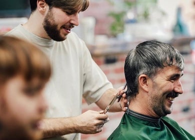 Barber expertly cutting a customer's hair at Lishmans Barbershop, Newcastle upon Tyne, England, GB.