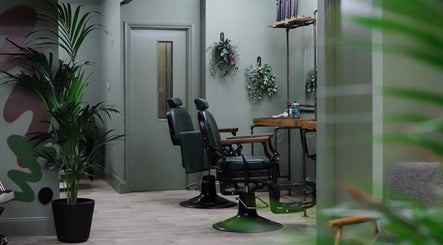 Modern interior of Lishmans Barbershop, Newcastle upon Tyne, England, GB with stylish barber chairs and greenery.