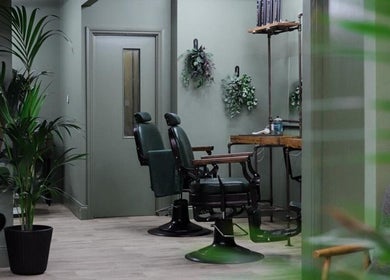 Elegant interior of Lishmans Barbershop with classic chairs and greenery in Newcastle upon Tyne, England, GB.