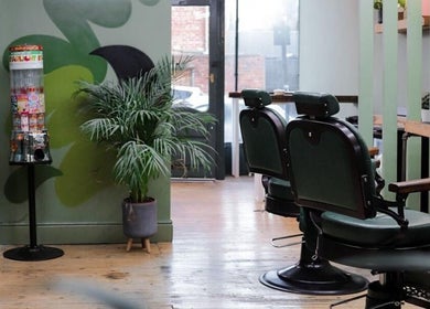 Inviting interior of Lishmans Barbershop in Newcastle upon Tyne, England, GB with barber chairs and vibrant decor.