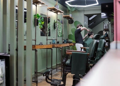 Modern interior of Lishmans Barbershop in Newcastle upon Tyne, England, GB showing a stylist at work.