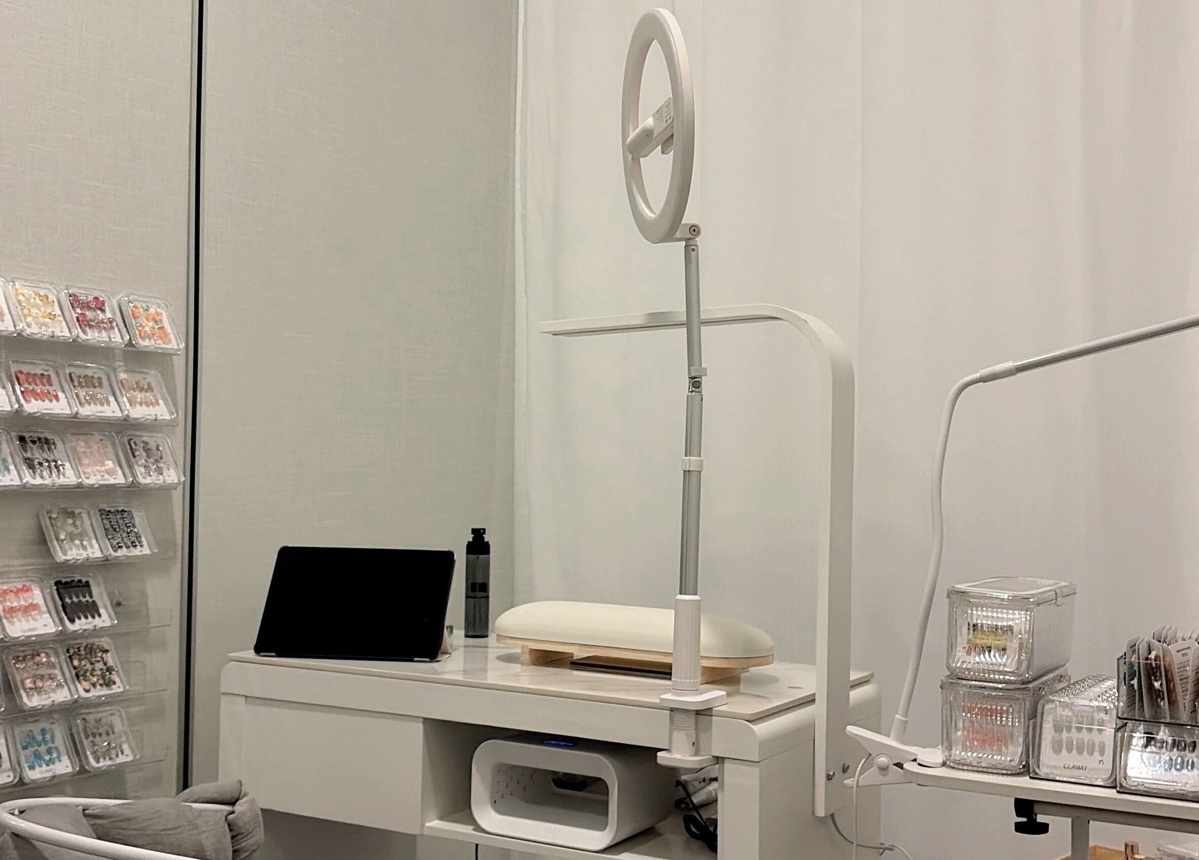 Modern nail studio at clawdsg, SG, SG, showcasing organized nail art supplies and sleek white furniture.