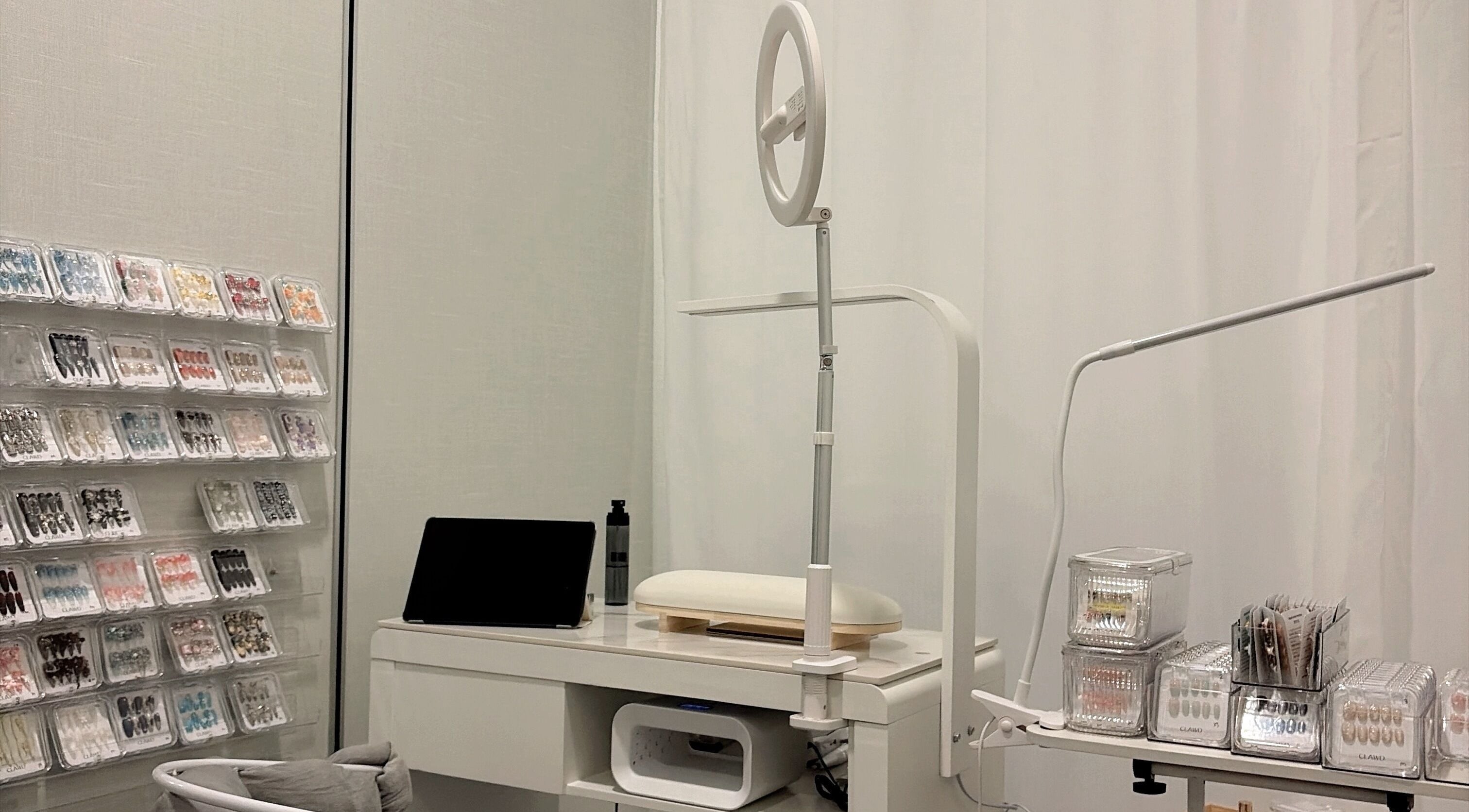 Modern nail studio at clawdsg, SG, SG, showcasing organized nail art supplies and sleek white furniture.