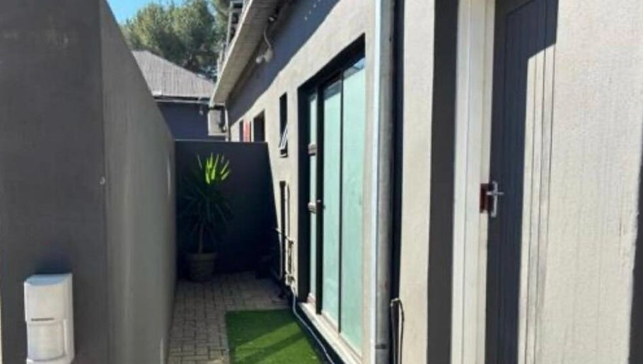 Tranquil side entrance at MUA SGO MELAX, Bloemfontein, Free State, ZA, with plants and modern architecture.