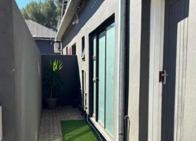 Tranquil side entrance at MUA SGO MELAX, Bloemfontein, Free State, ZA, with plants and modern architecture.