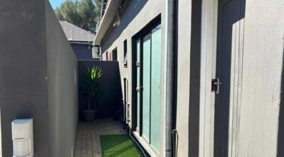 Tranquil side entrance at MUA SGO MELAX, Bloemfontein, Free State, ZA, with plants and modern architecture.