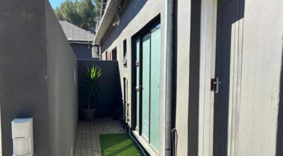 Tranquil side entrance at MUA SGO MELAX, Bloemfontein, Free State, ZA, with plants and modern architecture.