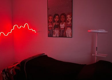 Cozy treatment room at Bratzified Beauty in Douglas, Arizona, US with red neon light and stylish decor.