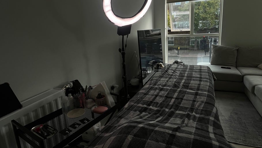 Cozy treatment room at AV aestheticz in London, England, GB with a ring light and comfortable couch.