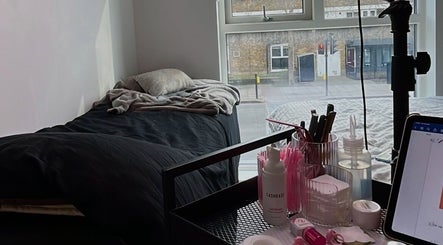 AV aestheticz's cozy treatment space in London, England, GB, featuring a comfy bed and beauty products.