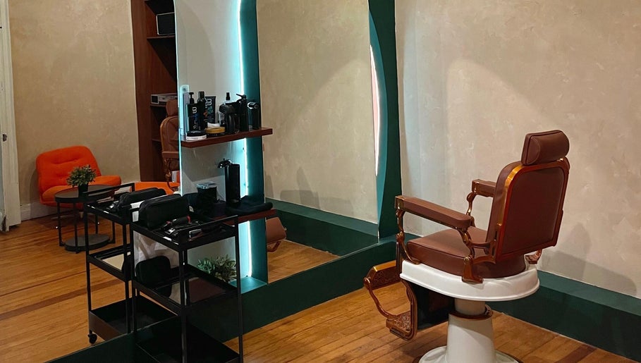 Interior del Grizzly Barber Club en Ciudad De México con silla de barbero clásica y decoración moderna.
