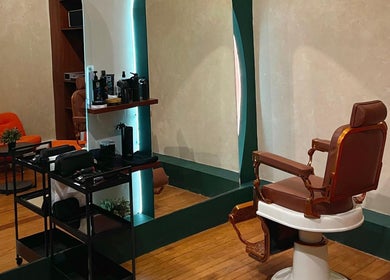 Interior del Grizzly Barber Club en Ciudad De México con silla de barbero clásica y decoración moderna.