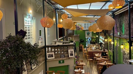 Área de espera iluminada con lámparas colgantes en Grizzly Barber Club, Ciudad De México, Ciudad De México, MX.
