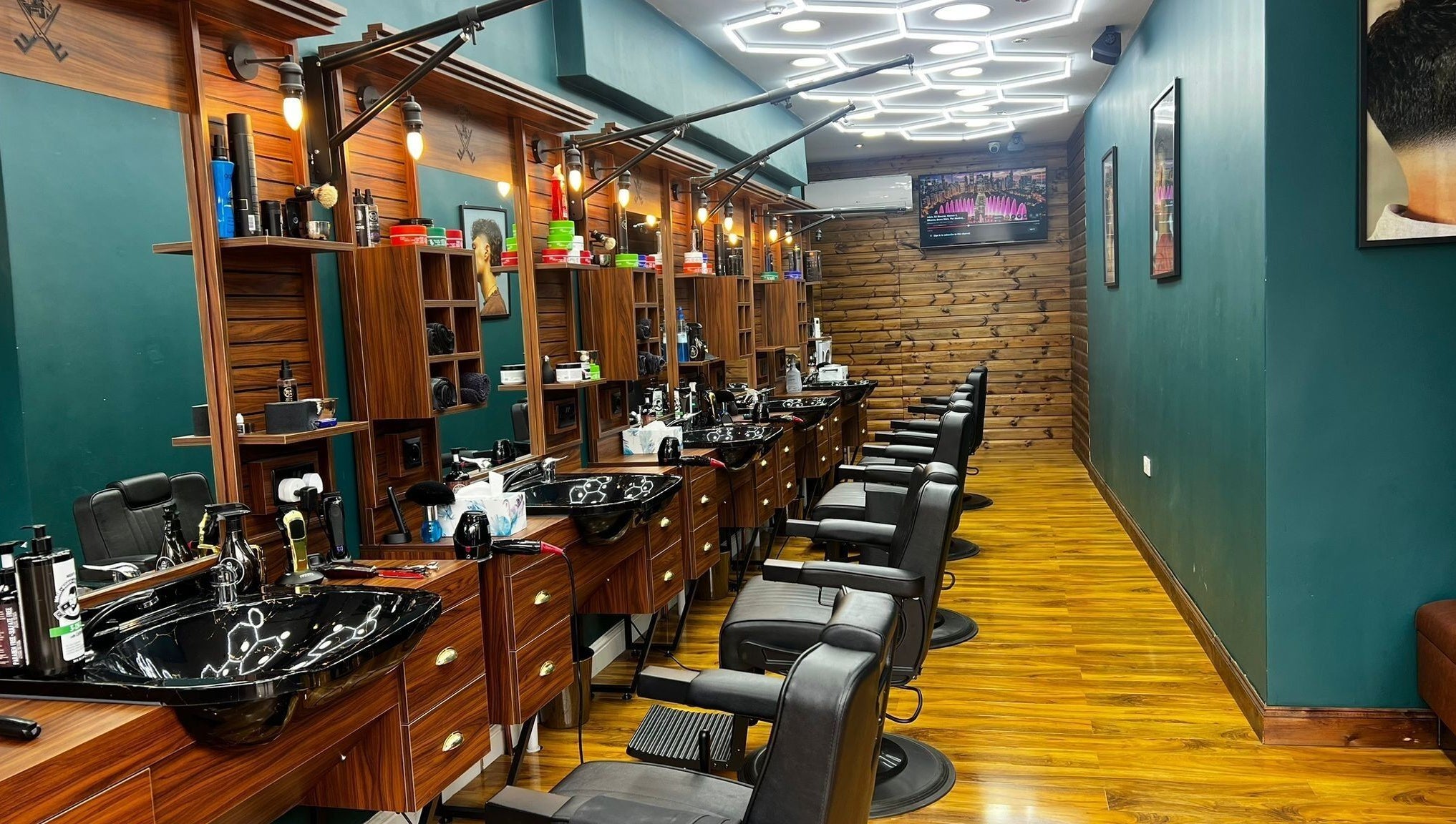 Fade Factory - Balham in London, England, GB features sleek black chairs and wood accents for a modern salon experience.