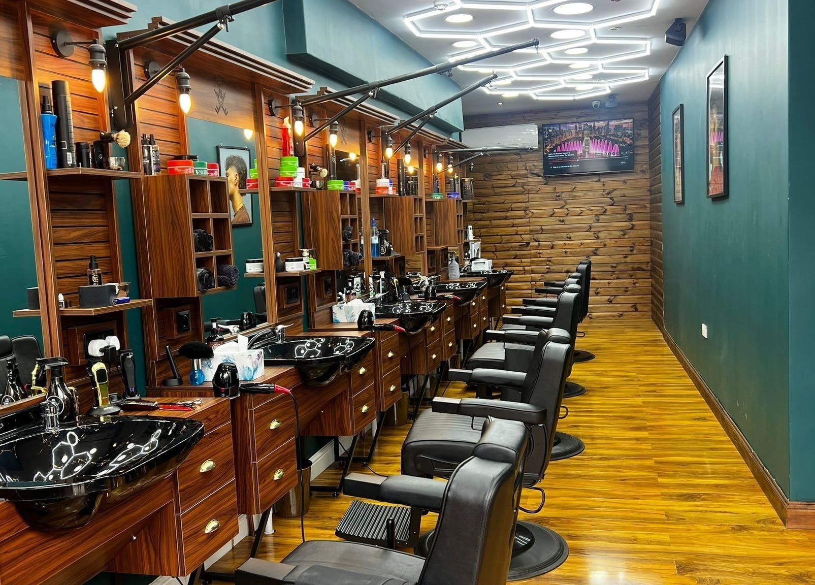 Fade Factory - Balham in London, England, GB features sleek black chairs and wood accents for a modern salon experience.