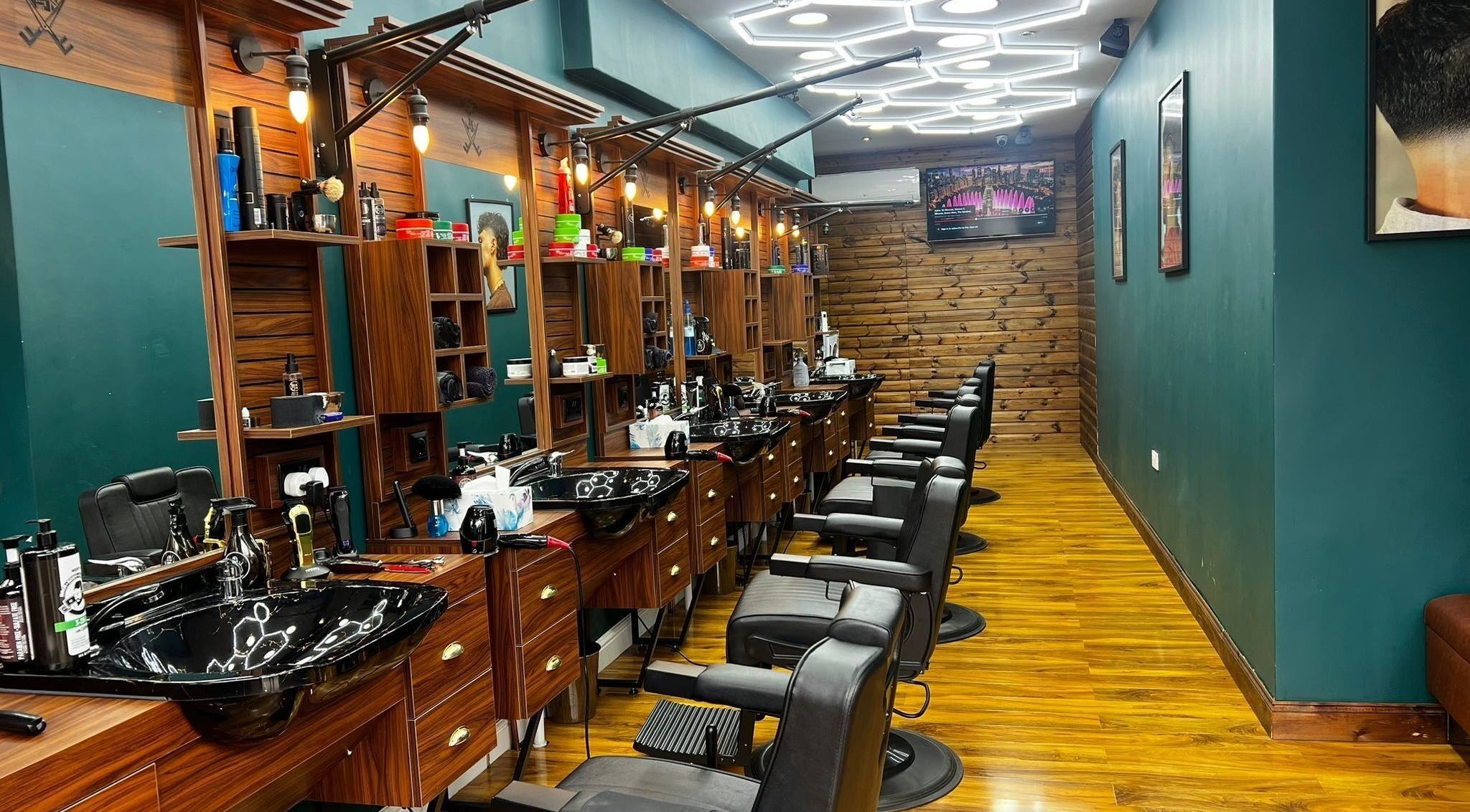 Fade Factory - Balham in London, England, GB features sleek black chairs and wood accents for a modern salon experience.