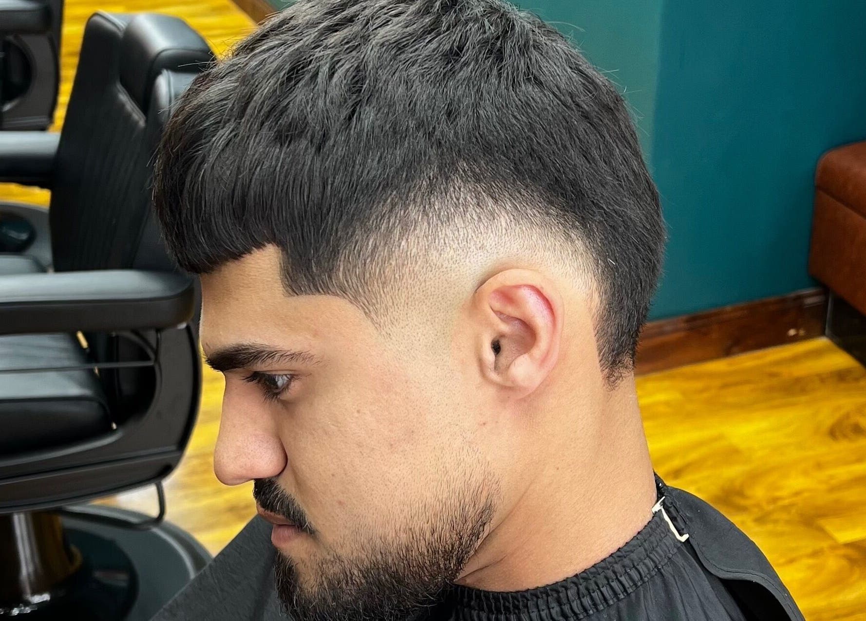 Man with fresh fade haircut at Fade Factory - Balham, London, England, GB. Barber chair visible in modern salon.