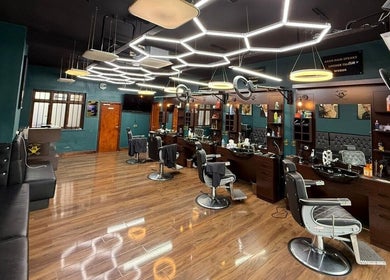 Stylish interior of Fade Factory, a modern beauty salon in Morden, England, GB with sleek design and barber chairs.