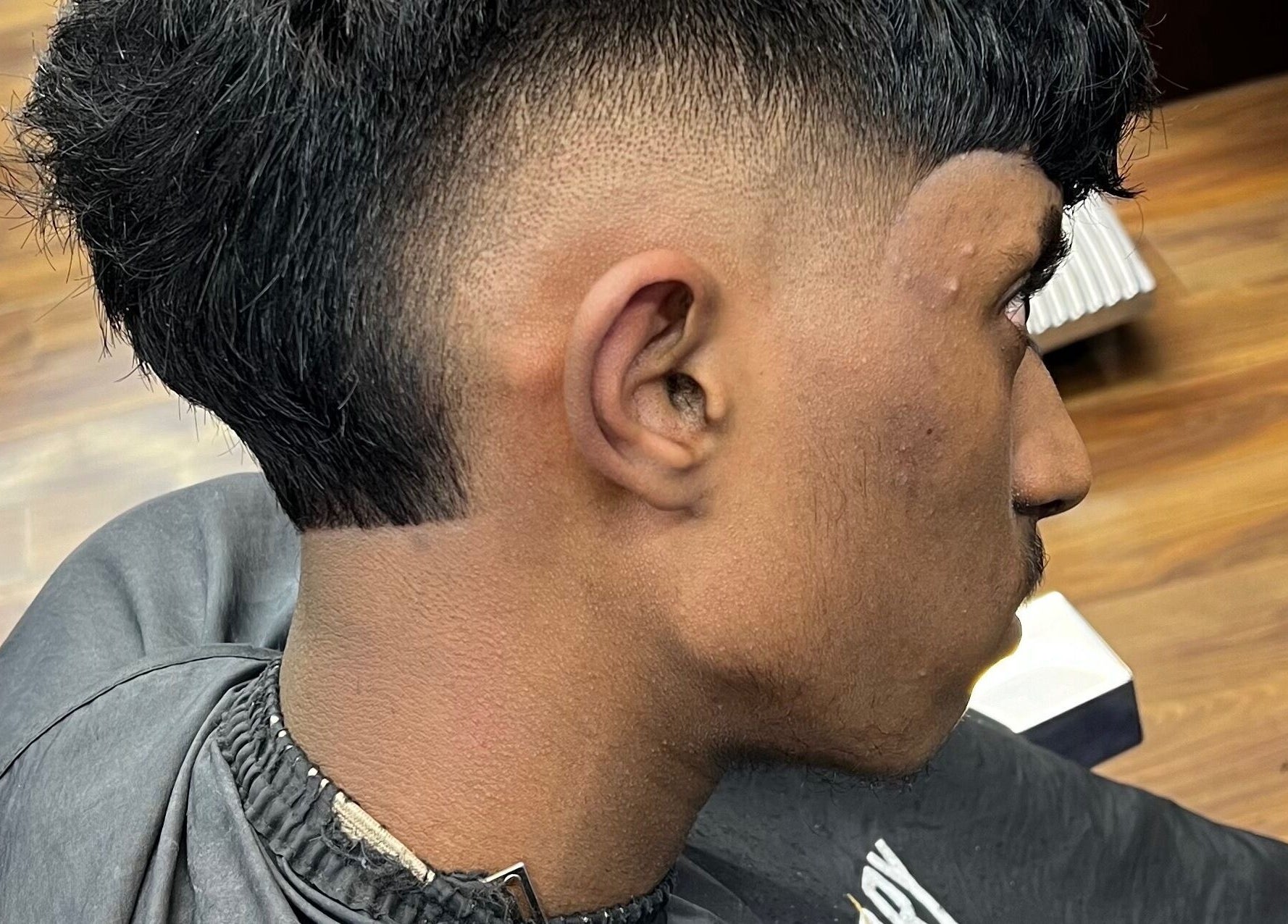 Close-up of a stylish men's haircut at Fade Factory, Morden, England, GB showcasing sharp fade design.