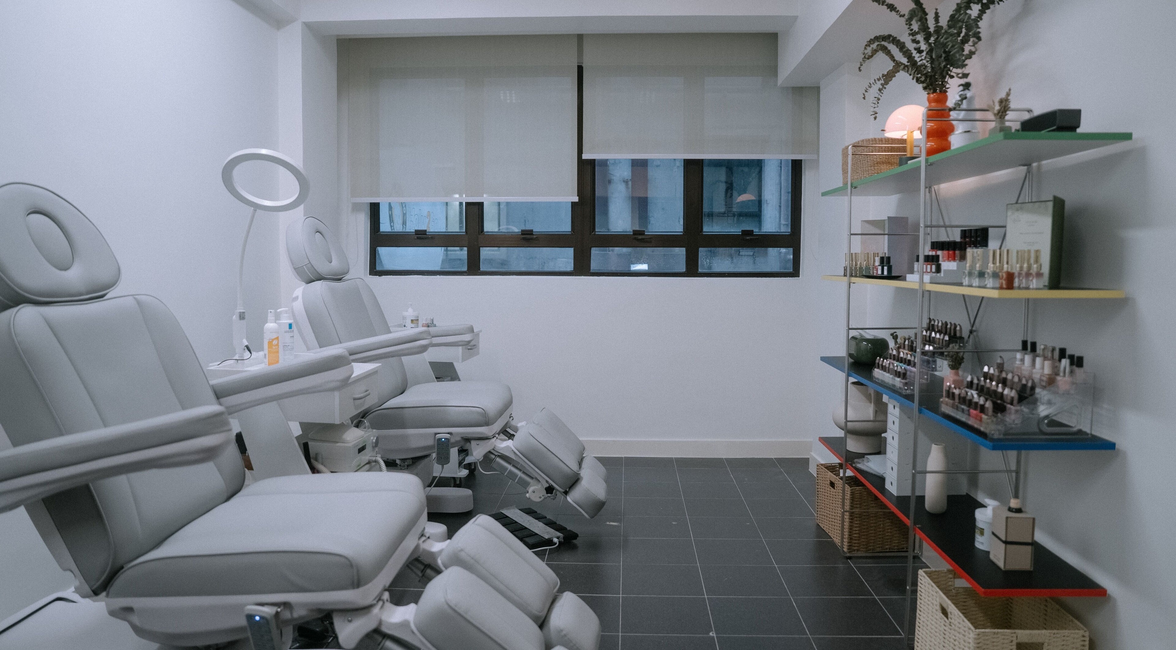 Modern interior of Mercredi. Mani and Pedi in Central, Hong Kong Island, HK with elegant spa chairs and nail polish display.