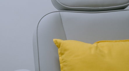 Comfy white chair with a bright yellow cushion at Mercredi. Mani and Pedi, Central, Hong Kong Island, HK.