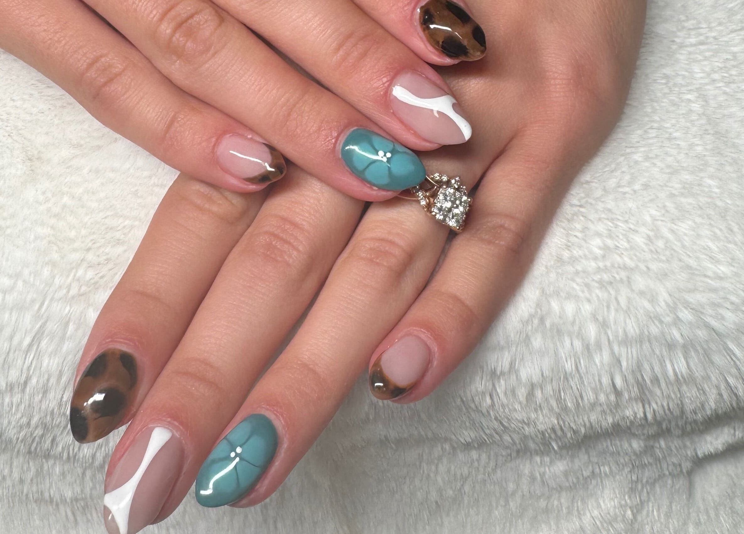 Intricate nail art at NailsByMaycee in Estill Springs, Tennessee, US. A blend of teal, white, and animal print designs.