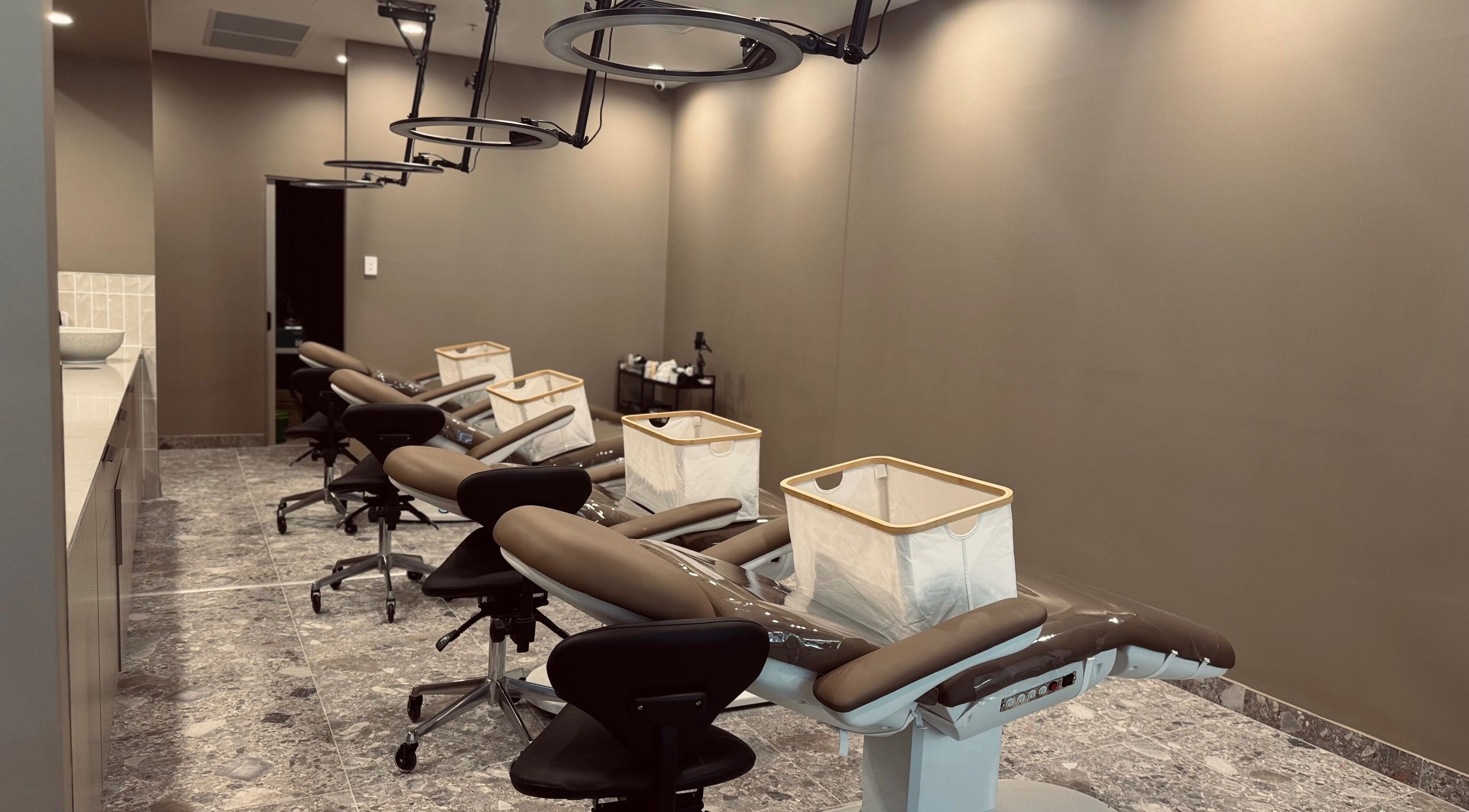 Modern beauty treatment room at Bureau of Beauty, Yeerongpilly, Queensland, AU with sleek chairs and equipment.