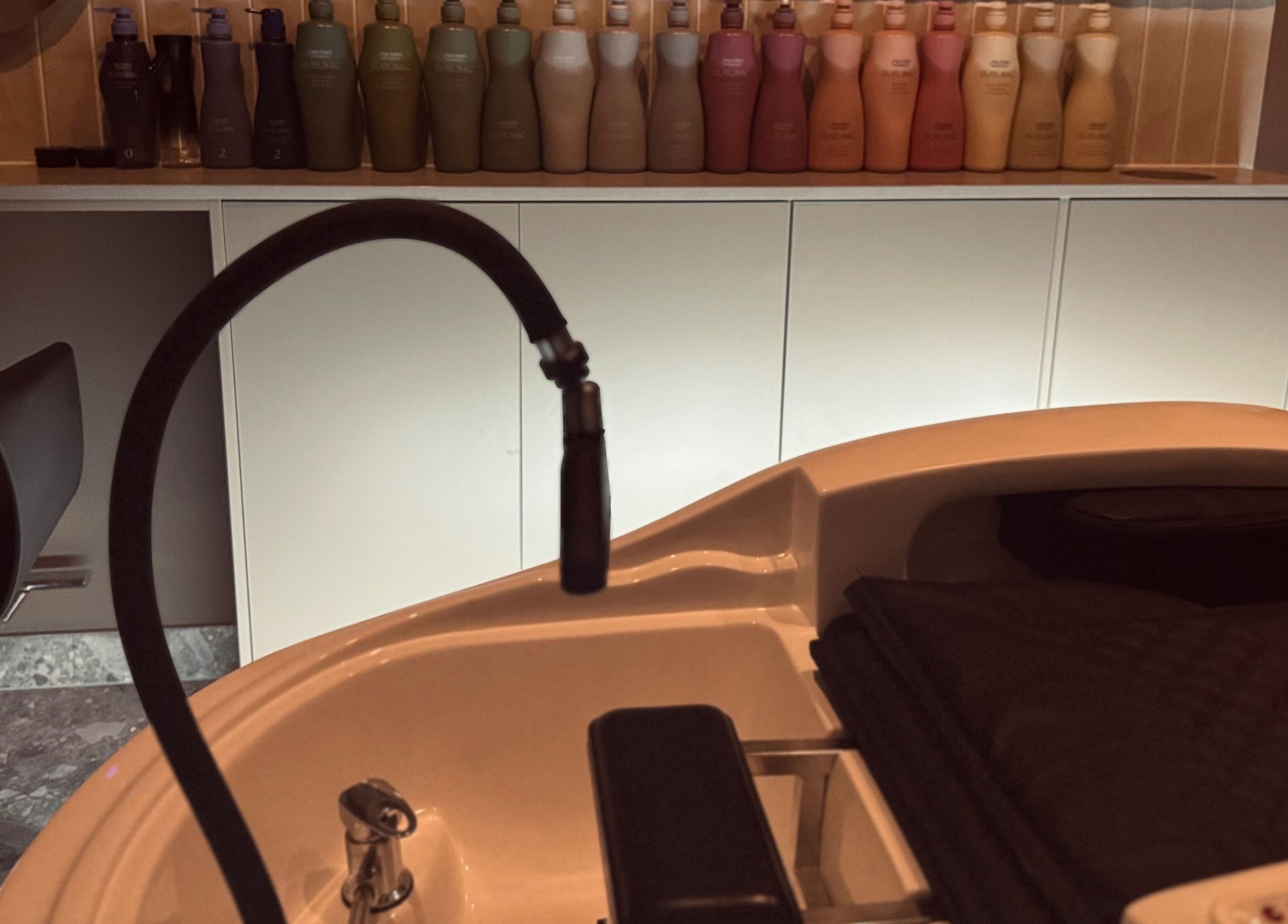 Modern hair washing station at Bureau of Beauty, Yeerongpilly, Queensland, AU, with stylish seating and product display.