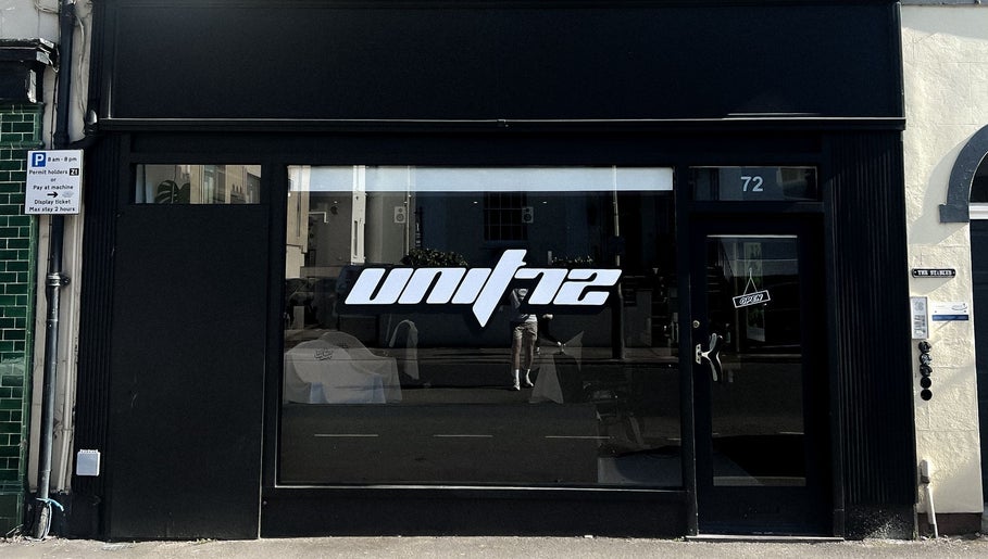 Exterior of Unit 72 Barbershop at 72, Cheltenham, England, GB showcasing modern black signage.