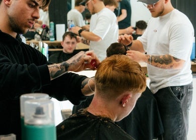 Barbers styling hair at Unit 72 Barbershop in Cheltenham, England, GB. Modern and professional grooming services.