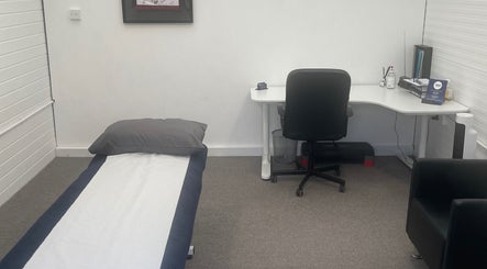 Private treatment room at 360 Healthcare Hub, Wigan, England, GB, featuring a therapy bed and desk.