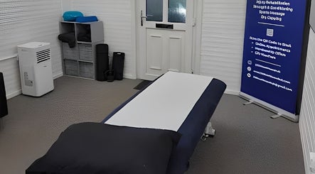 A serene treatment room at 360 Healthcare Hub in Wigan, England, GB, featuring a massage table and cozy decor.