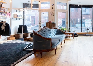 Cozy seating area in Revolution Hair Studio | St-Henri, Montréal, Québec, CA with large windows and chic decor.