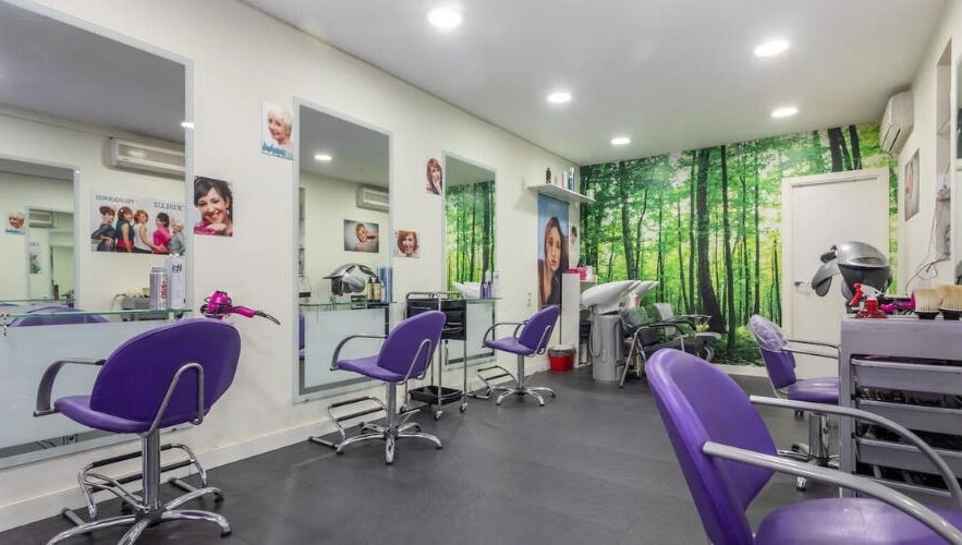 Interior moderno del salón CRISLUZ en Madrid, Comunidad De Madrid, ES con sillas moradas y mural de bosque.