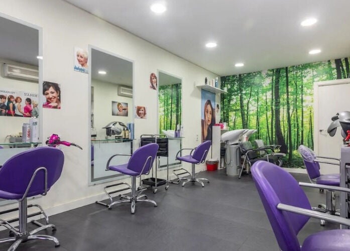 Interior moderno del salón CRISLUZ en Madrid, Comunidad De Madrid, ES con sillas moradas y mural de bosque.