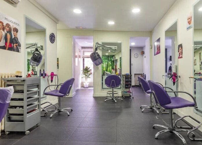 Interior del salón CRISLUZ en Madrid, Comunidad De Madrid, ES con sillas moradas y decoración moderna.