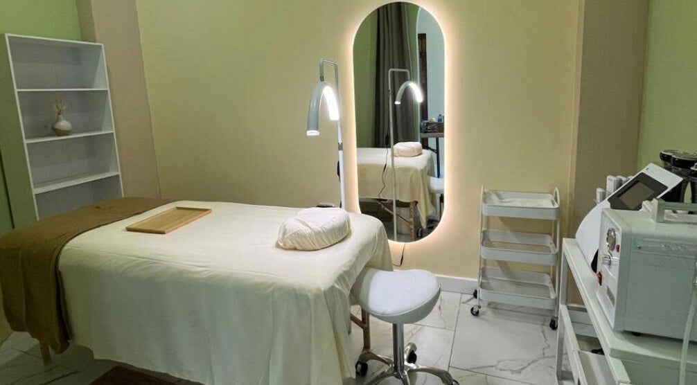 Sala de tratamiento en ZACI SPA, Tijuana, Baja California, MX, con mesa de masaje blanca y espejo iluminado.