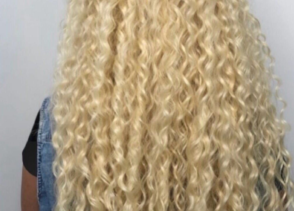 Luxe Beauty Portsmouth showcases voluminous blonde curls styled elegantly, enhancing natural beauty.