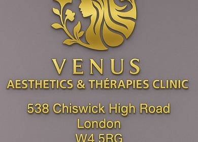 Venus Clinic logo and address in gold lettering on gray wall, located in London, England, GB.