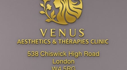Venus Clinic logo and address in gold lettering on gray wall, located in London, England, GB.