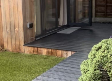 Outdoor terrace at Sculpt Labs - Marple in Stockport, England, GB with natural wood and lush greenery.